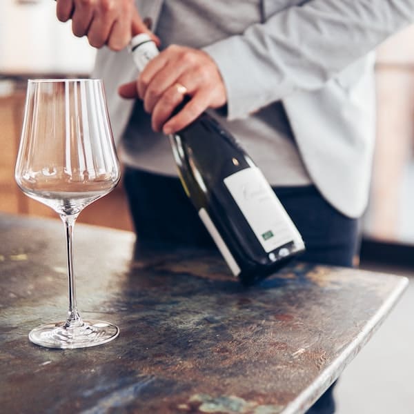 Un homme ouvrant une bouteille de vin